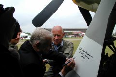 Bud signing the Scandinavian Historic Flight SHF P-51 Old Crow as owner Anders Saether looks on. Duxford, England. 2001