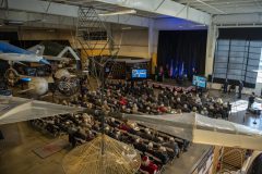 Connie Bowlin, podium, a close friend of retired Col. Clarence E. “Bud” Anderson, delivers a special tribute during a ceremony presided by Air Force Chief of Staff Gen. CQ Brown, Jr. promoting Anderson to the honorary rank of brigadier general at the Aerospace Museum of California in McClellan, California, Dec. 2, 2022. The ceremony was an opportunity to honor the 100-year-old World War II triple ace during the 75th anniversary year of the U.S. Air Force’s establishment as a military service. (U.S. Air Force photo by Nicholas Pilch)